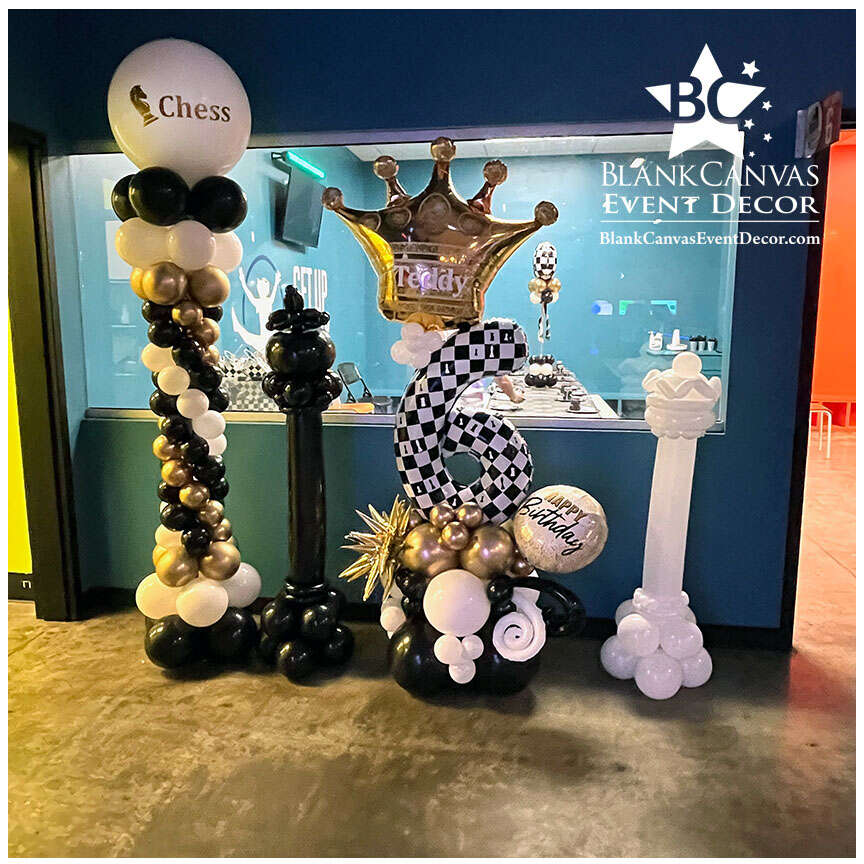 2 jumbo chess piece sculptures, a chess centerpiece with custom vinyl detail, a roman style balloon column with vinyl wording, and a deluxe single digit balloon billboard with his name on the crown and chess piece detail on the number 6.